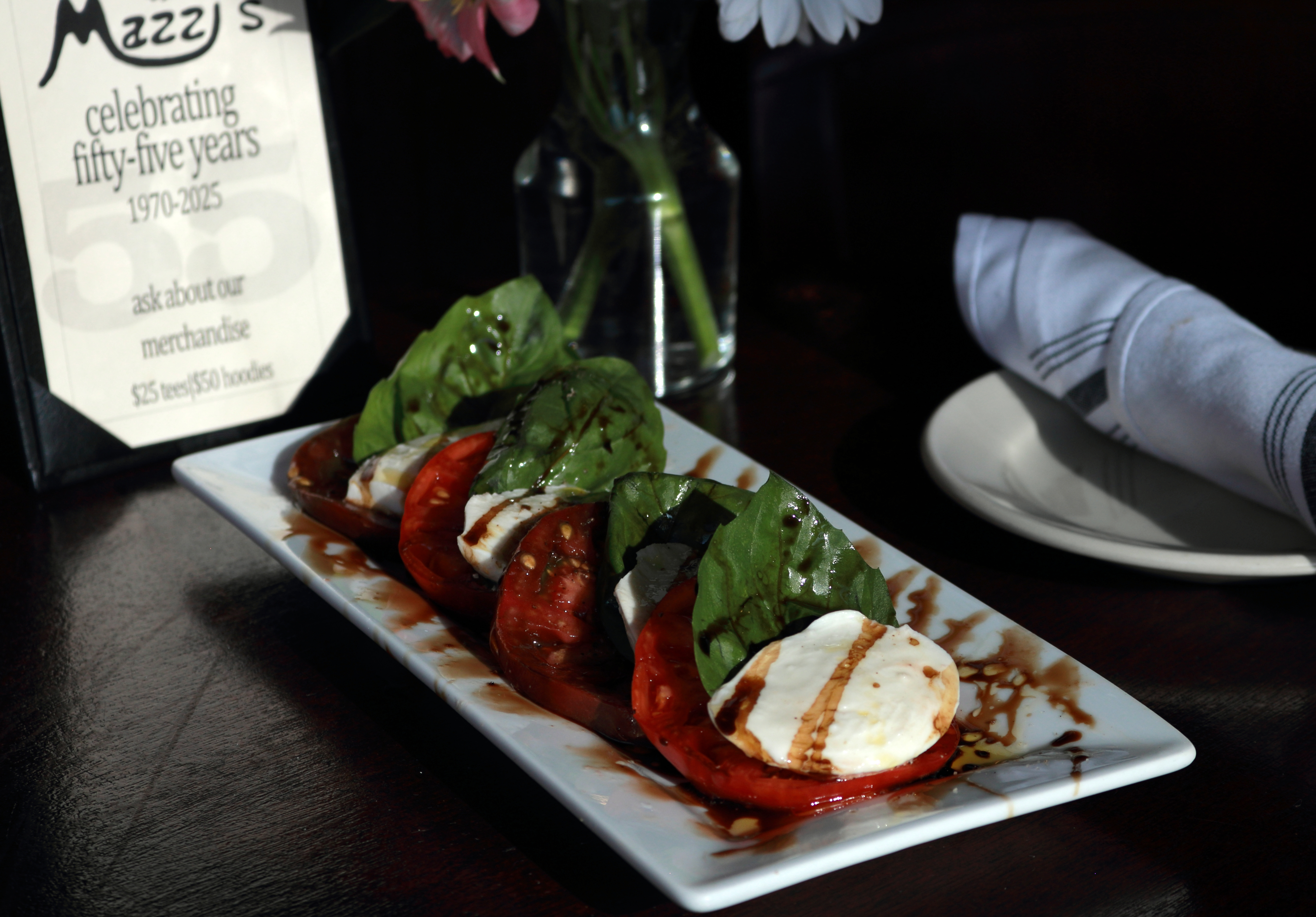 Farm-Fresh caprese salad, basil, sliced mozzarella, and heirloom tomatoes, topped with extra virgin olive oil, balsamic vinaigrette, salt and pepper